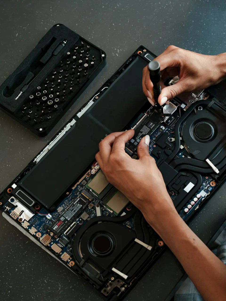 Técnica realizando manutenção interna em um notebook